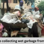 A gruop of people throwing garbage in garbage collector van